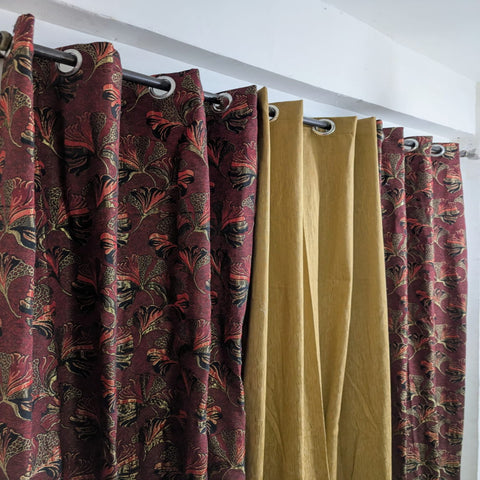 Patterned red and gold curtains on a white wall