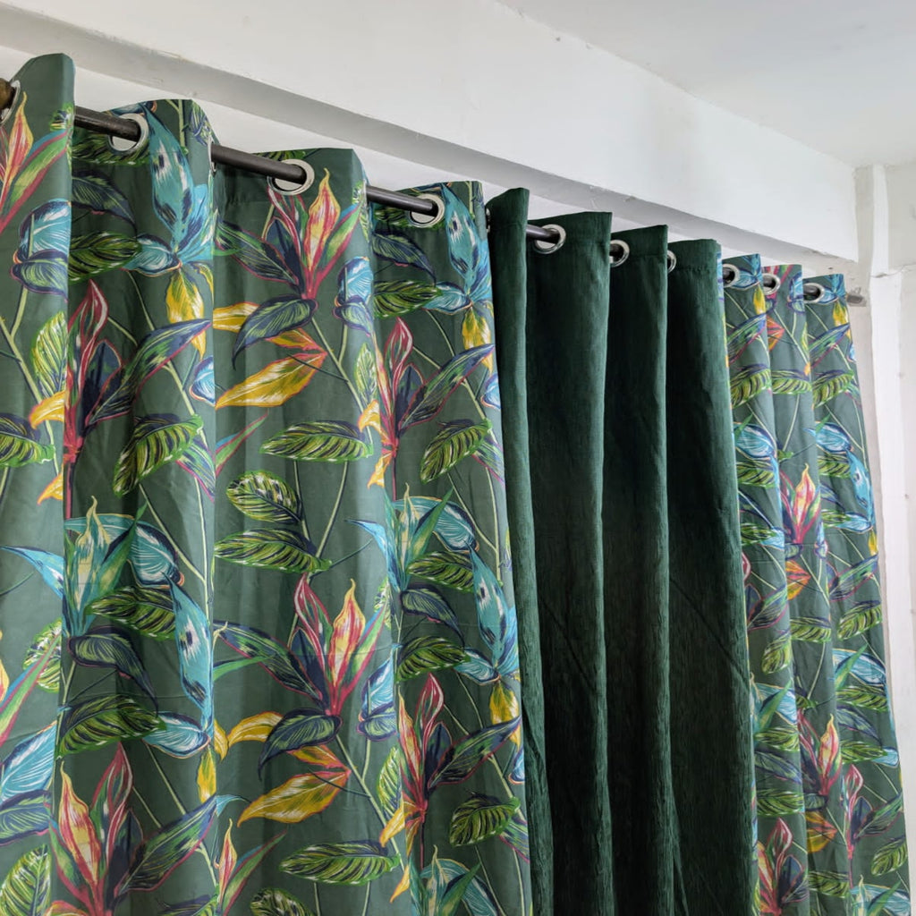 Green curtains with colorful leaf pattern on a white wall background