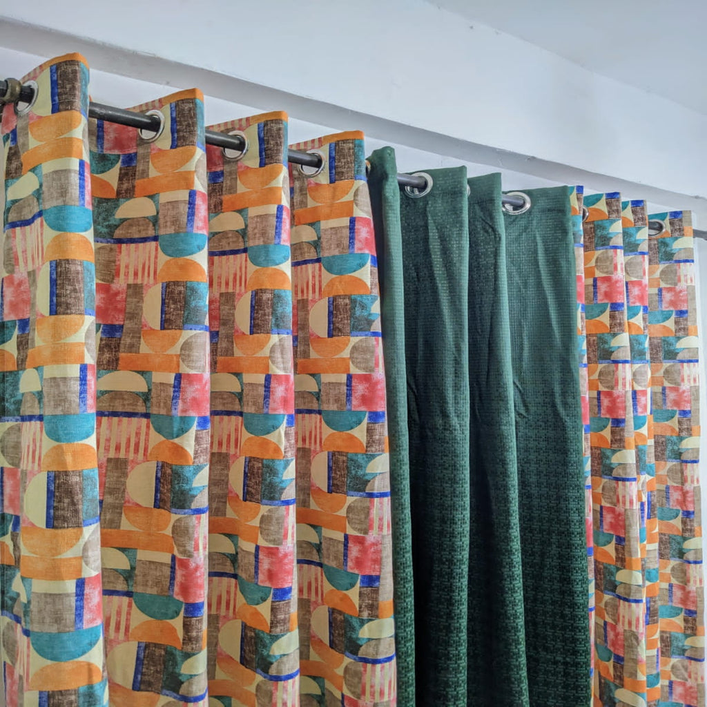 Colorful patterned curtains with geometric designs on a white wall background.