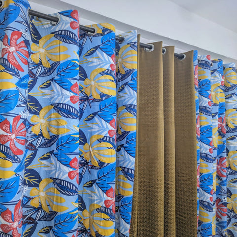 Hawaiian print curtains with blue, yellow, and red pattern on a white background
