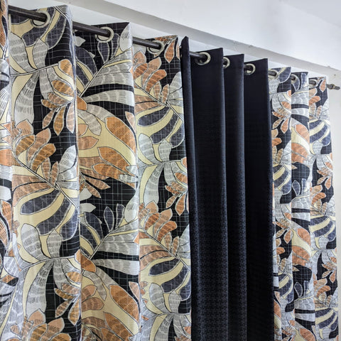 Patterned curtains with floral design in black, orange, and white.