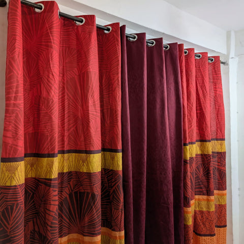 Red and maroon patterned curtains with yellow accents on a white background