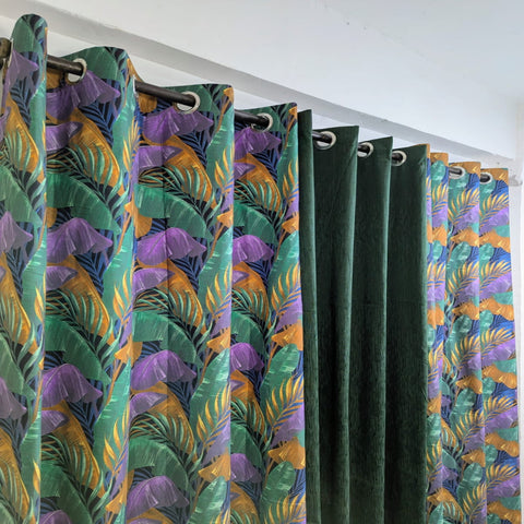 Patterned curtains with green, purple, and orange design on a white background