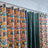 Colorful patterned curtains with geometric designs on a white wall background.