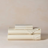 Set of beige bed sheets and pillowcases on a light beige background