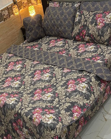 Floral patterned bedspread on a bed with pillows in a bedroom setting.