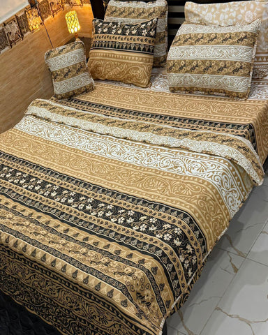 Decorative bedspread with intricate patterns on a bed in a room.